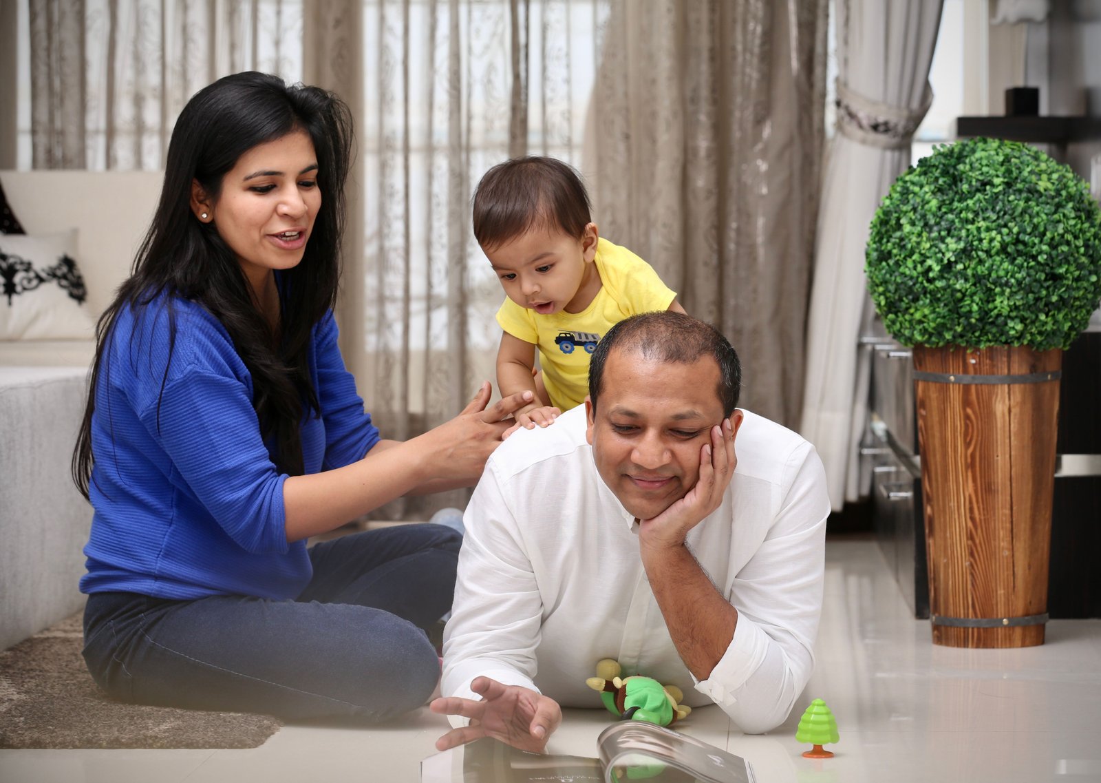 South Asian parents sharing a playful moment with their toddler at home